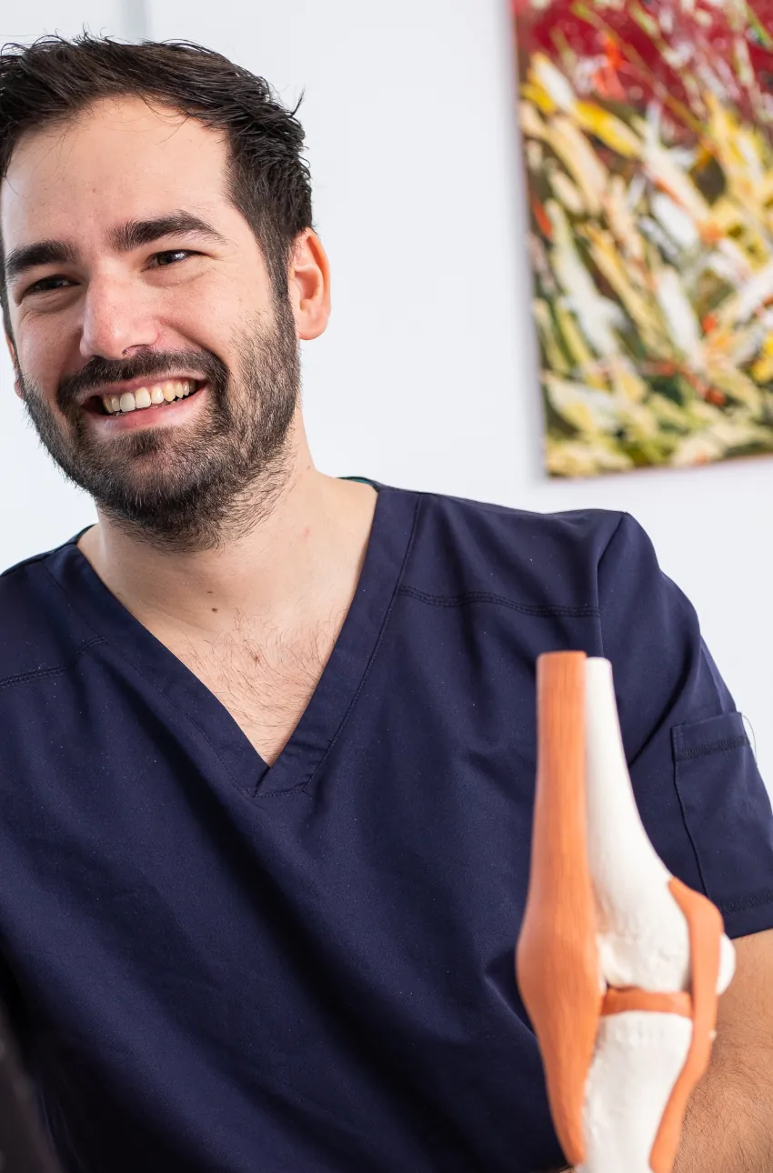 Dr. Patrik Shnawa in seiner Ordination mit einem anatomischen Kniemodell